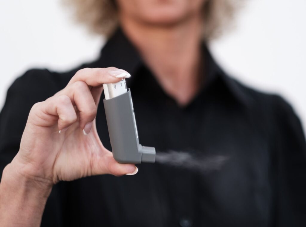 person using asthma inhaler